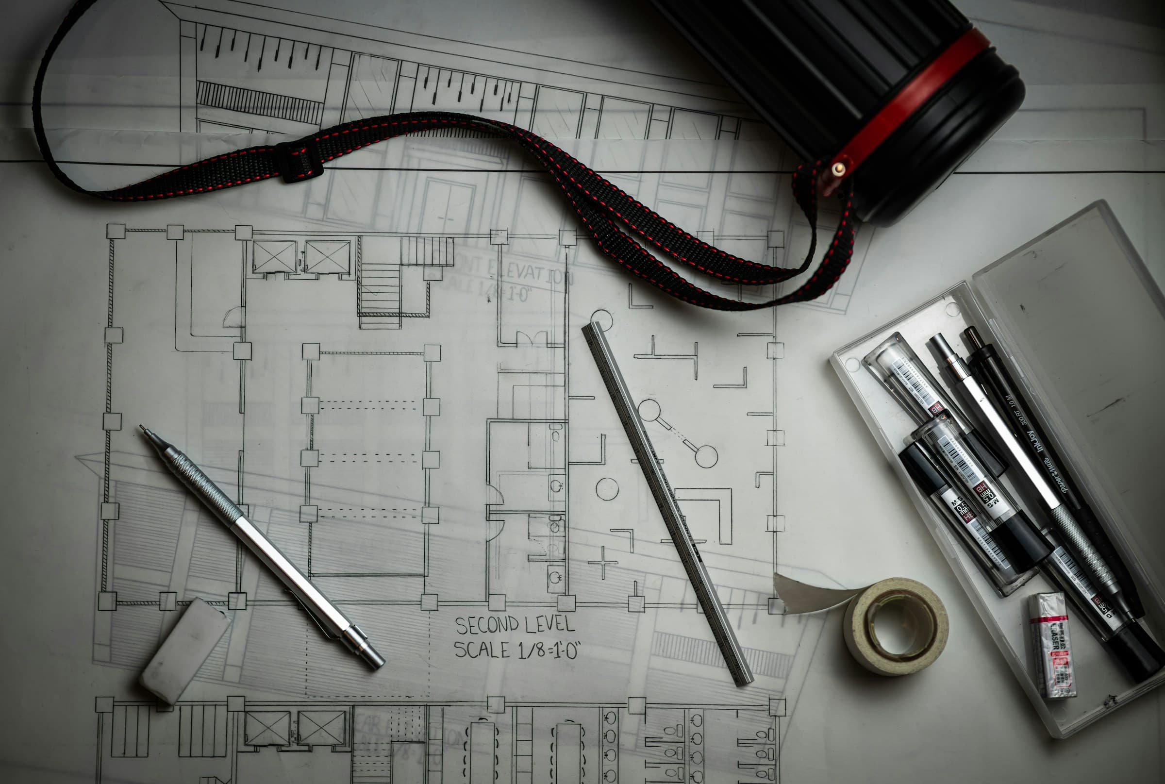 Blueprints with pens and a tape measure, seen from above