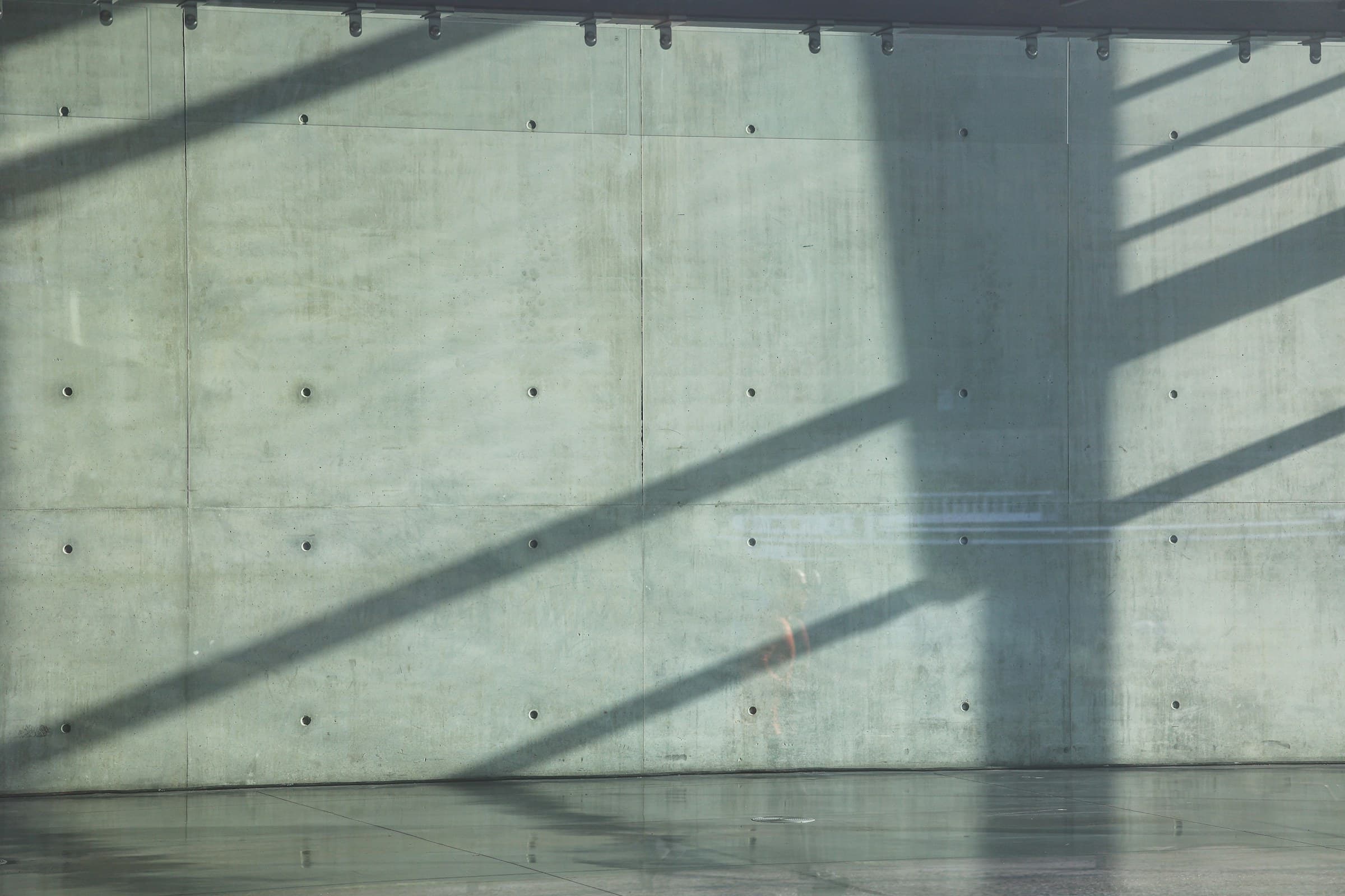 A concrete wall with diagonal light and shadow