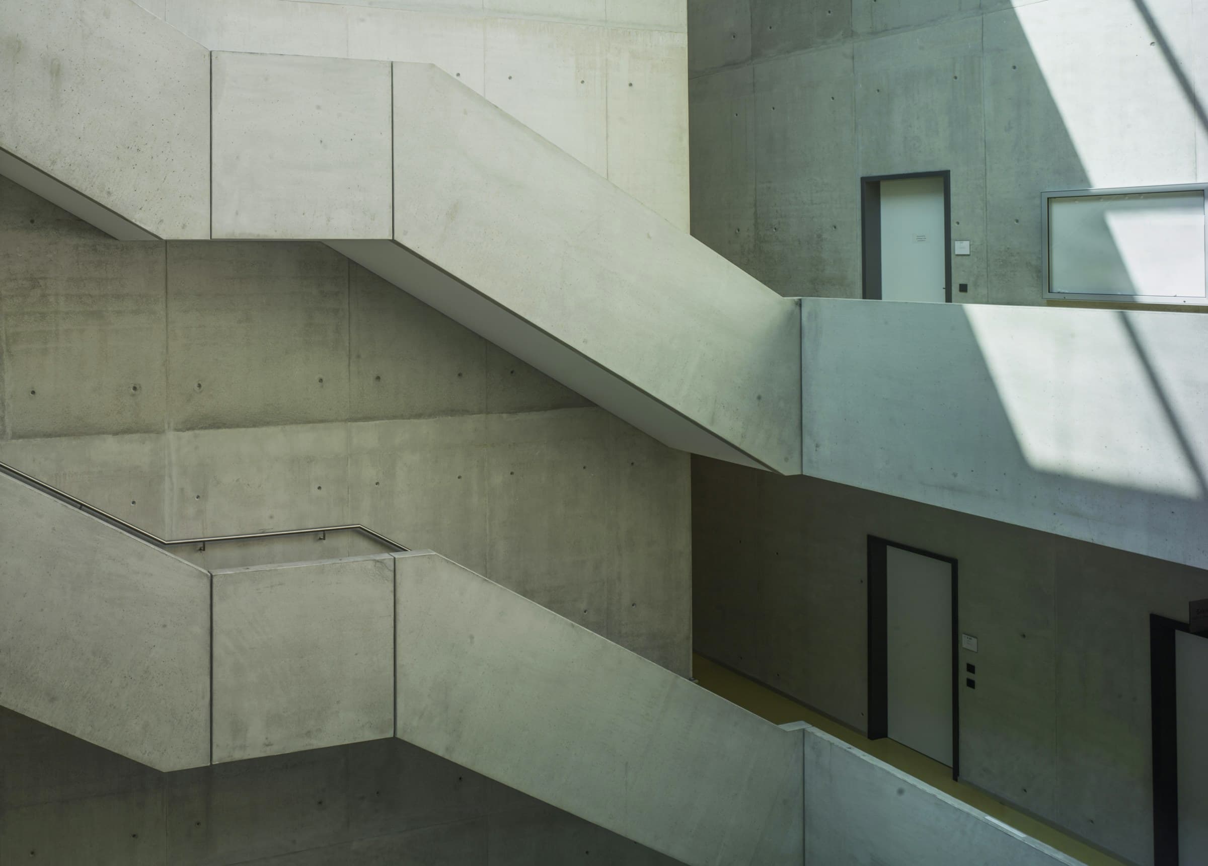 Concrete stairs between plain walls