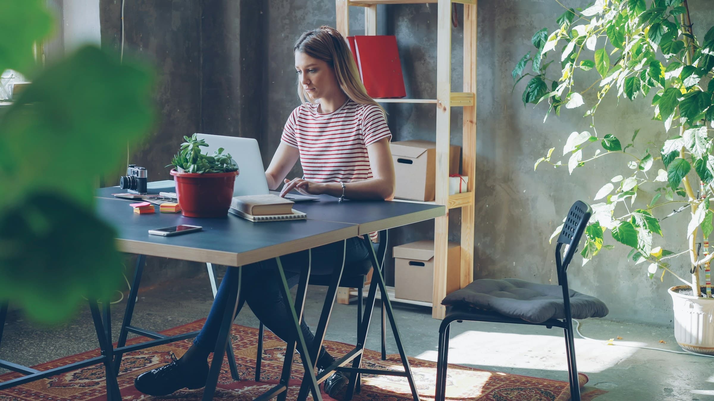 A woman working on a laptop at her desk