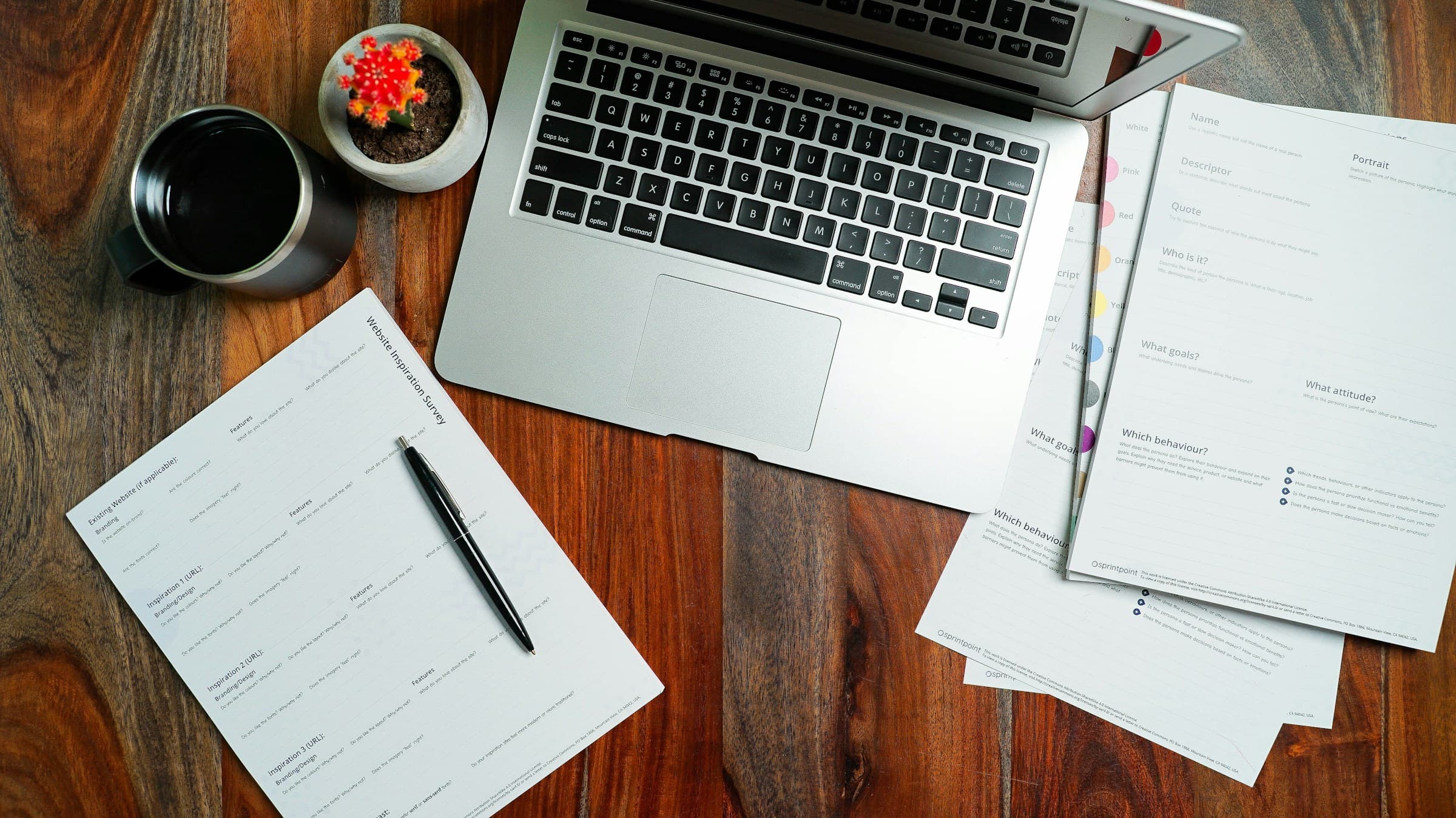A laptop and papers on a wooden desk