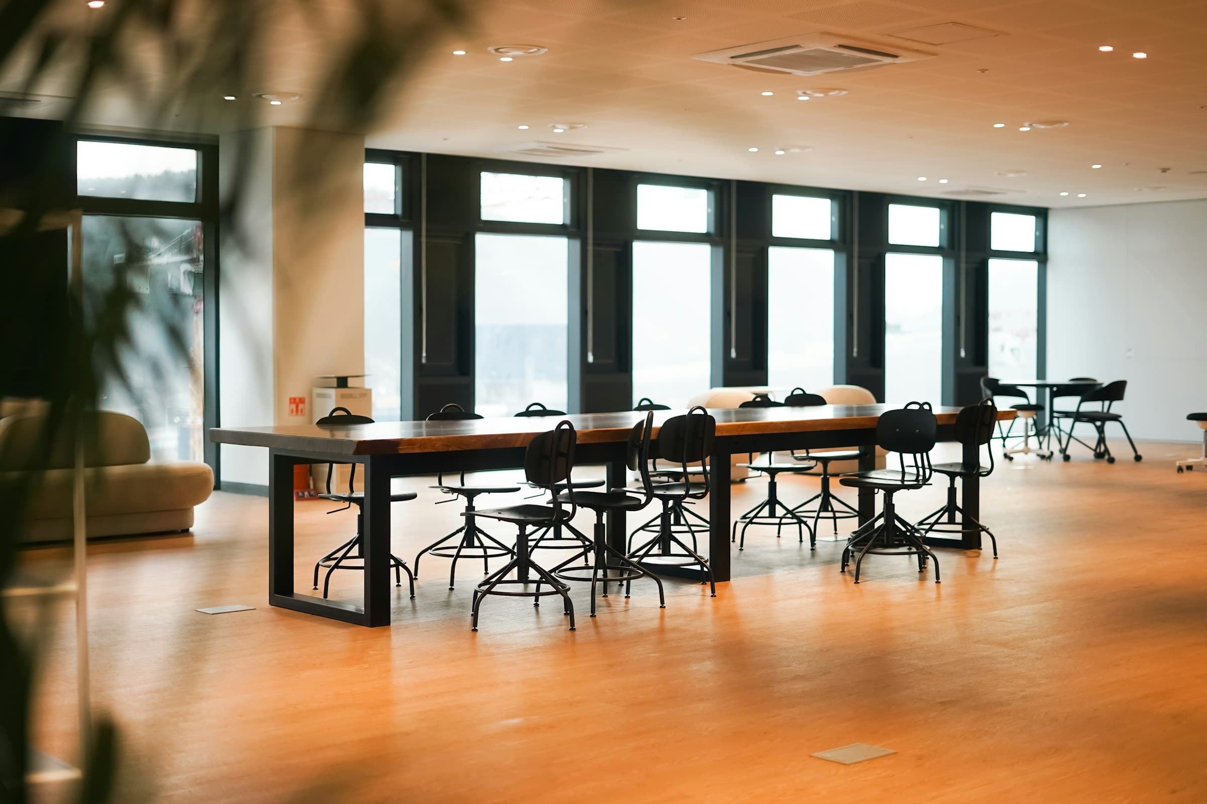 A bright meeting room with a long table on a wooden floor