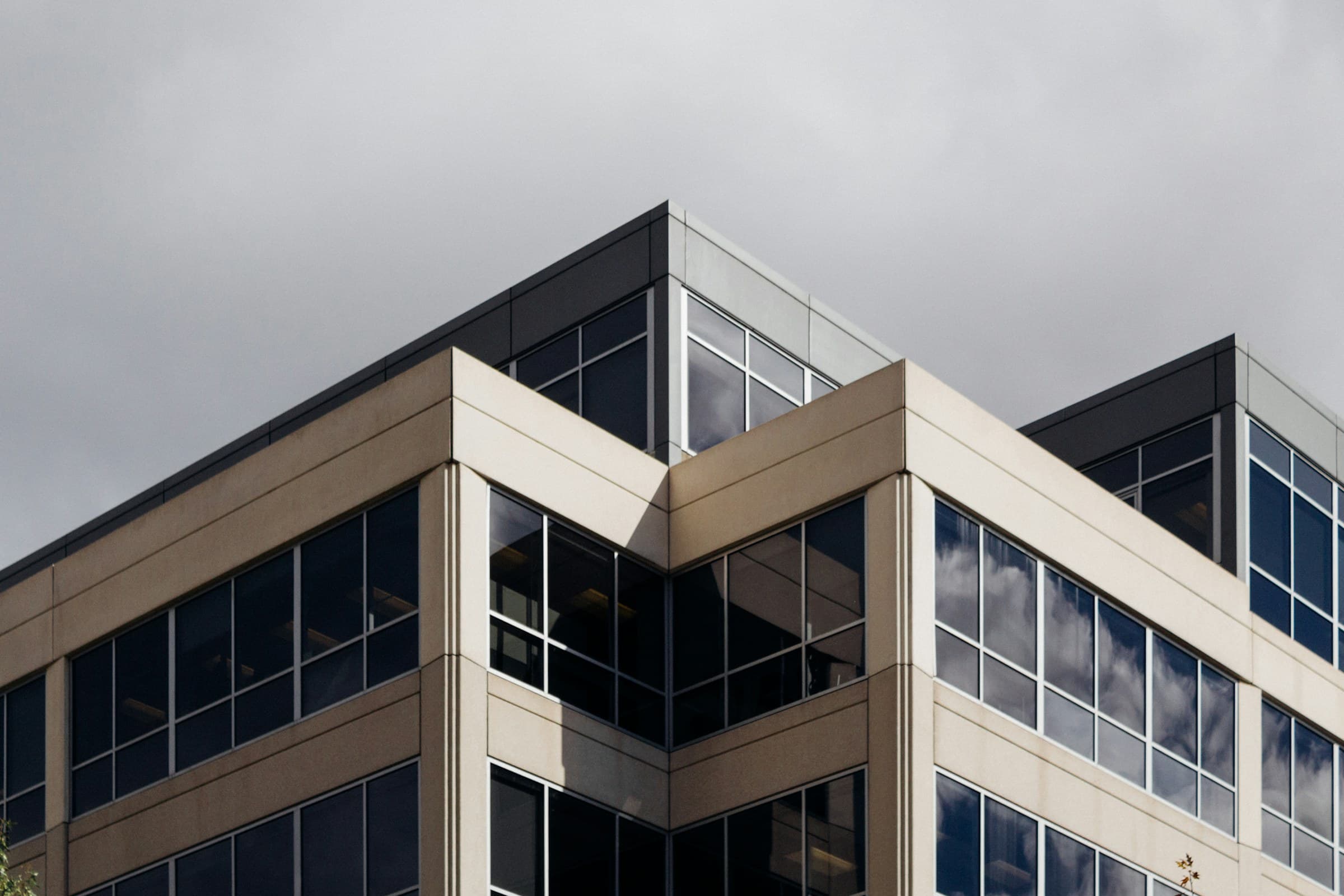 A beige-framed office building against a grey sky