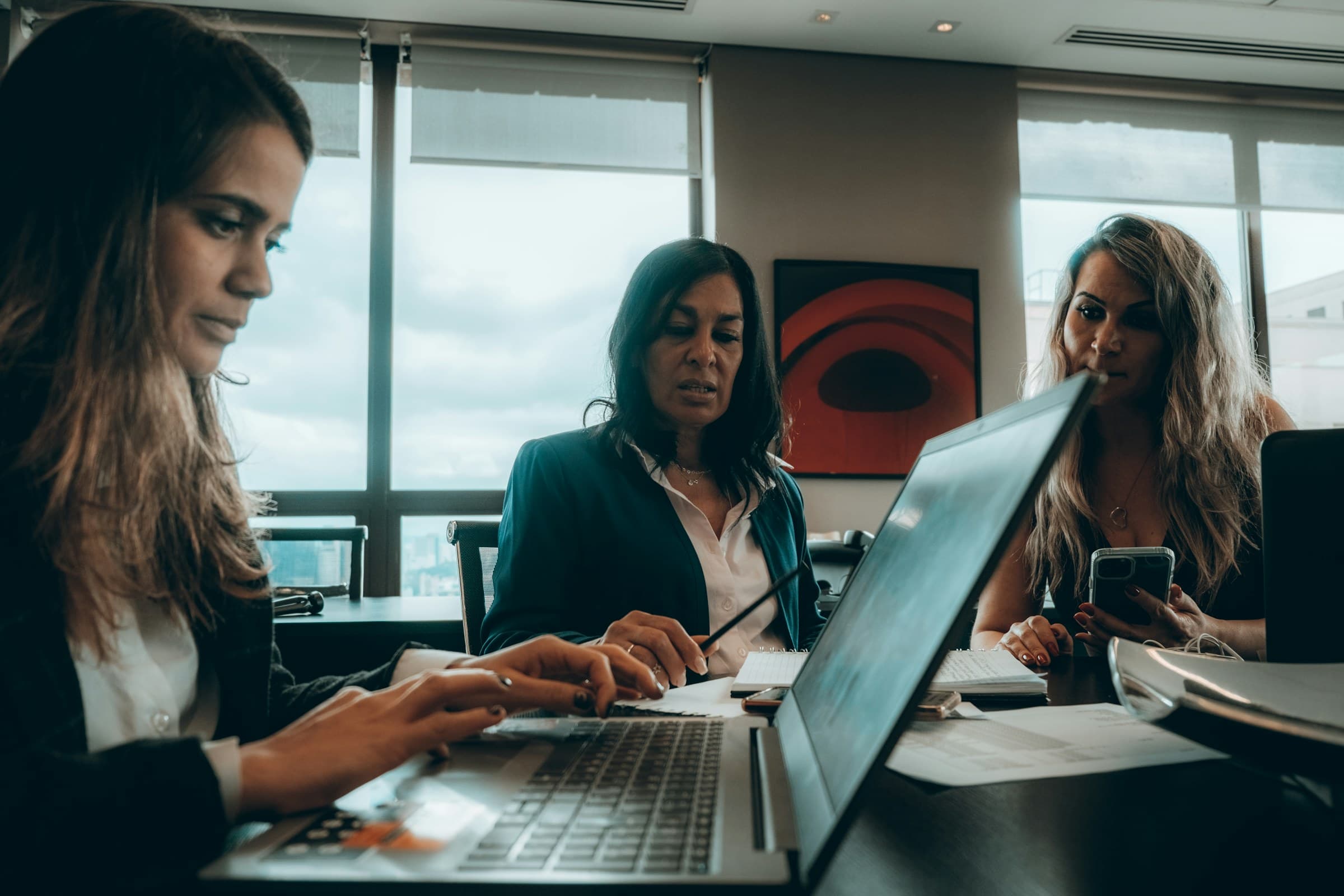 Three colleagues around a laptop