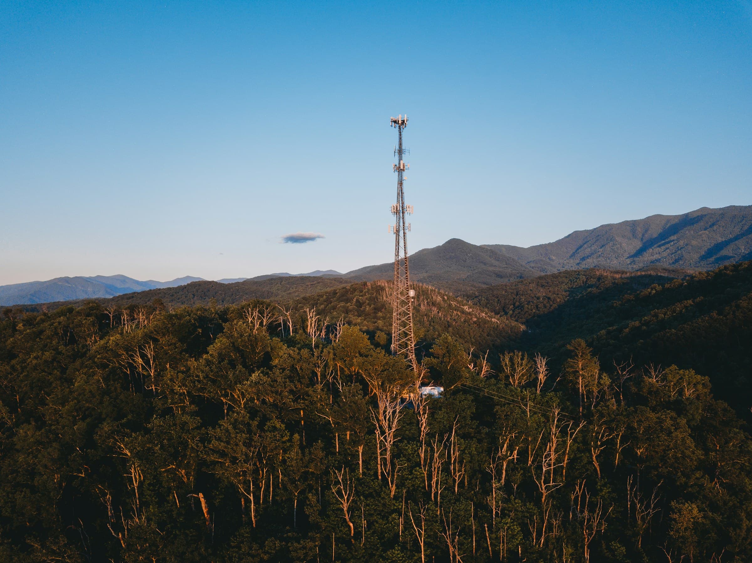 A telecom tower above forested hills
