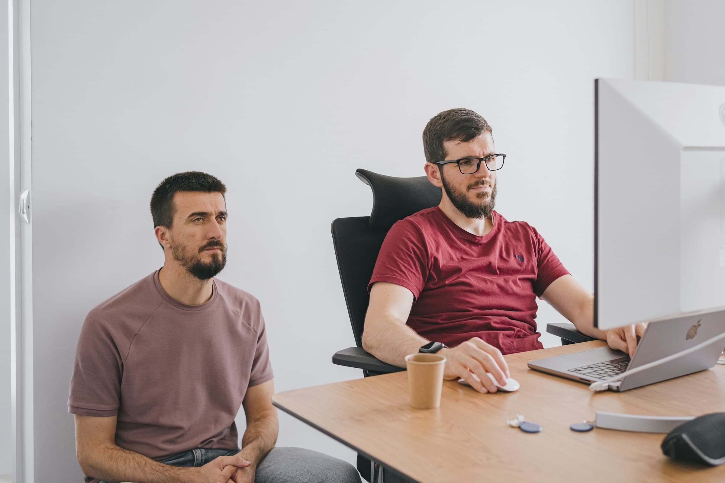 Two men at a table with a laptop